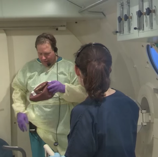 Dr. James Holm shows what happens to a football at 2.8 atmospheres of pressure. Image: Virginia Mason Hospital